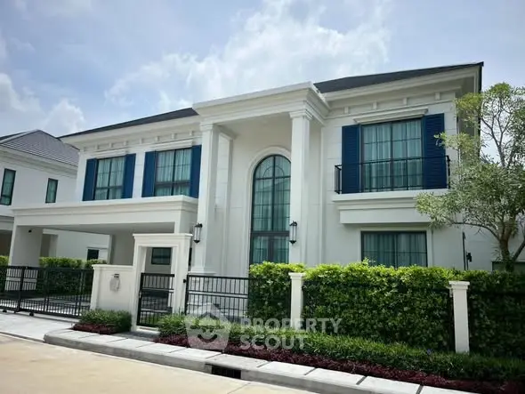 Luxurious modern villa with elegant facade and lush landscaping in upscale neighborhood.