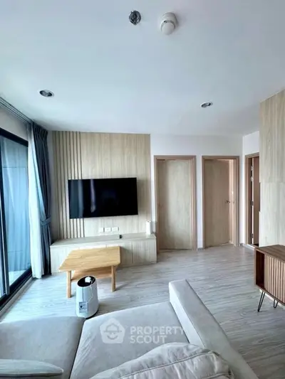 Modern living room with sleek wooden accents and large windows for natural light.