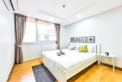 Bright and cozy bedroom with modern decor and large window for natural light.