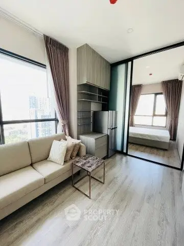 Modern living room with large windows and stylish furniture in a high-rise apartment.