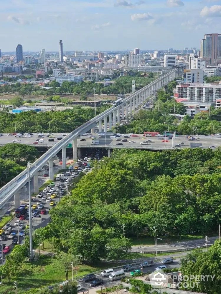 Stunning cityscape view with elevated train tracks and lush greenery, perfect for urban living enthusiasts.