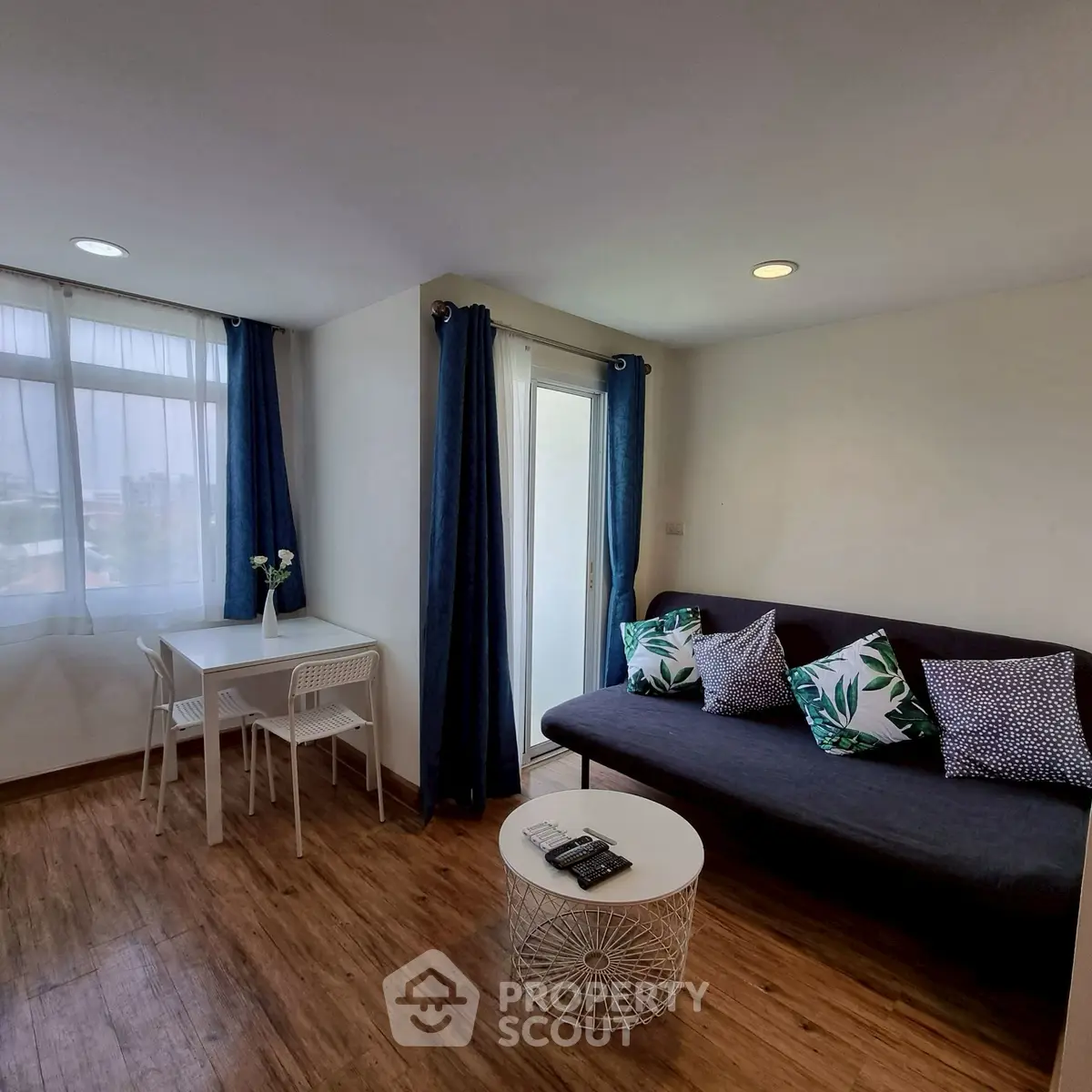 Modern living room with cozy sofa, stylish decor, and natural light from large windows.