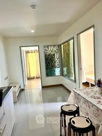 Bright and airy apartment interior with modern kitchen and dining area, featuring large windows and stylish decor.