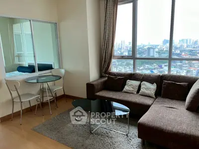 Modern living room with city view, cozy sofa, and dining area in a high-rise apartment.