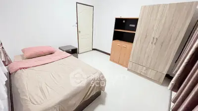 Cozy bedroom with single bed, wardrobe, and neutral decor