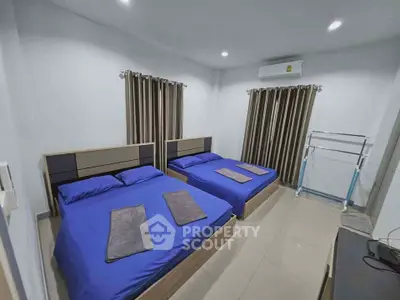 Spacious bedroom with two double beds, modern decor, and air conditioning for comfort.