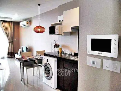 Modern open-plan kitchen with dining area and washing machine in stylish apartment.