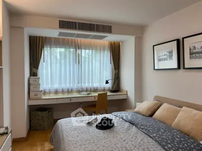 Cozy bedroom with a study nook, featuring a large window and elegant decor, perfect for relaxation and productivity.