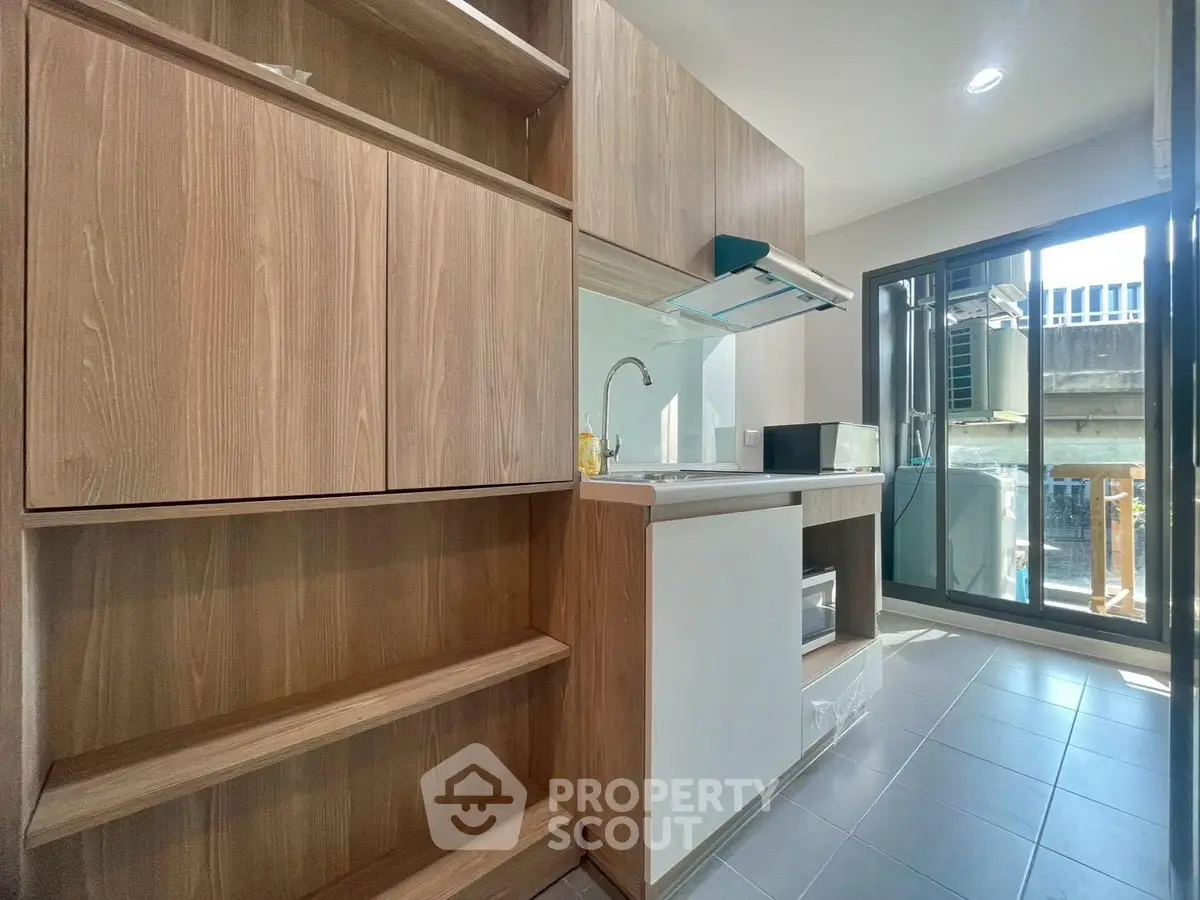 Modern kitchen with sleek wooden cabinets and large window for natural light
