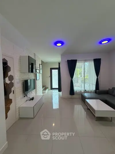 Modern living room with sleek design, featuring a cozy sofa, stylish lighting, and large windows for natural light.