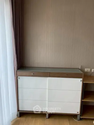 Modern interior with stylish wooden cabinet and elegant curtains in a cozy living space.