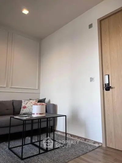 Modern living room with stylish sofa and coffee table, featuring elegant decor and wooden door.