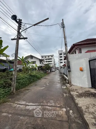 Charming residential street view with houses and lush greenery, perfect for serene living.