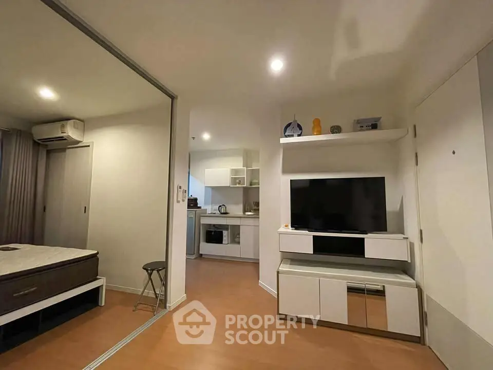 Modern studio apartment with open layout, featuring a cozy living area and compact kitchen.