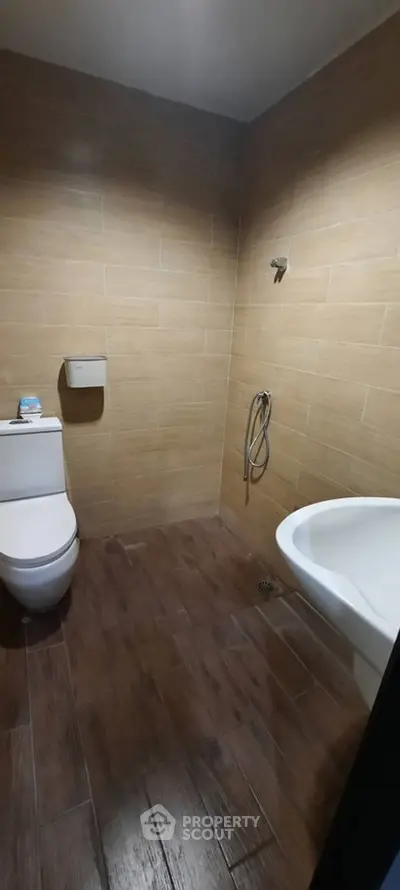 Modern bathroom with wooden tile flooring and sleek fixtures.