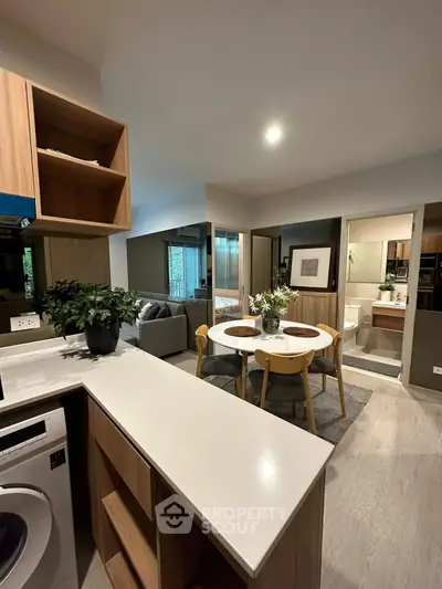 Modern open-plan living area with kitchen, dining, and cozy seating, featuring stylish decor and natural light.