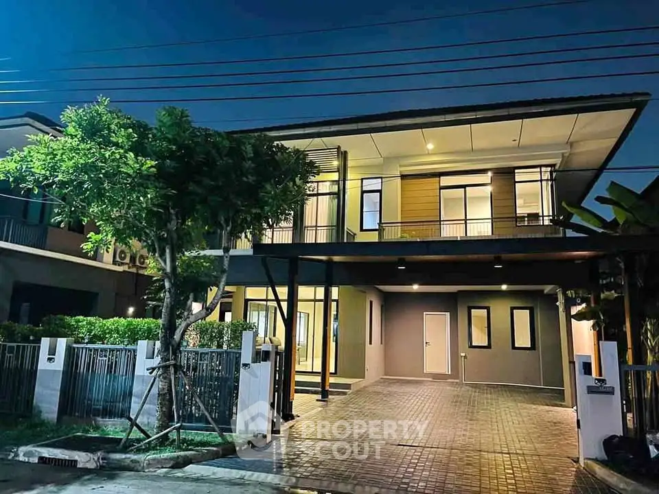 Modern two-story house with spacious driveway and elegant exterior lighting.