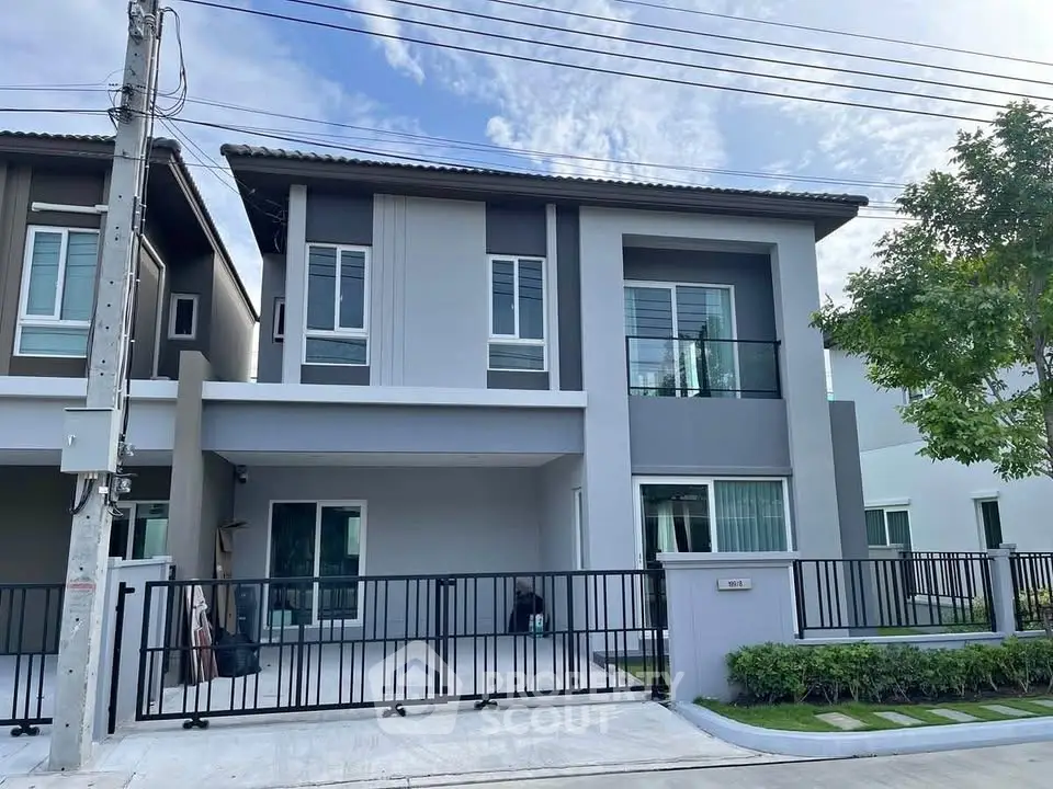 Modern two-story house with sleek design and spacious driveway in a serene neighborhood.