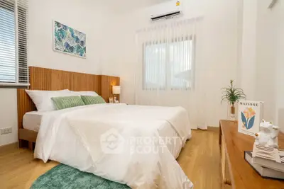 Cozy bedroom with modern decor and natural light, featuring a comfortable bed and stylish accents.