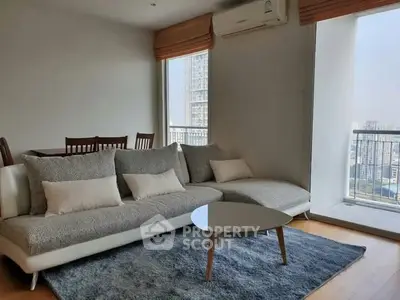 Modern living room with cozy sofa and city view balcony in high-rise apartment.