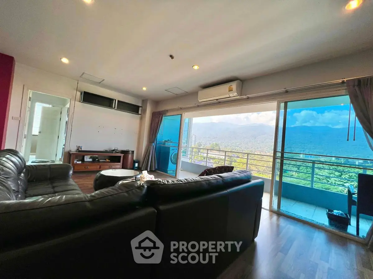 Spacious living room with stunning mountain view and large balcony access.
