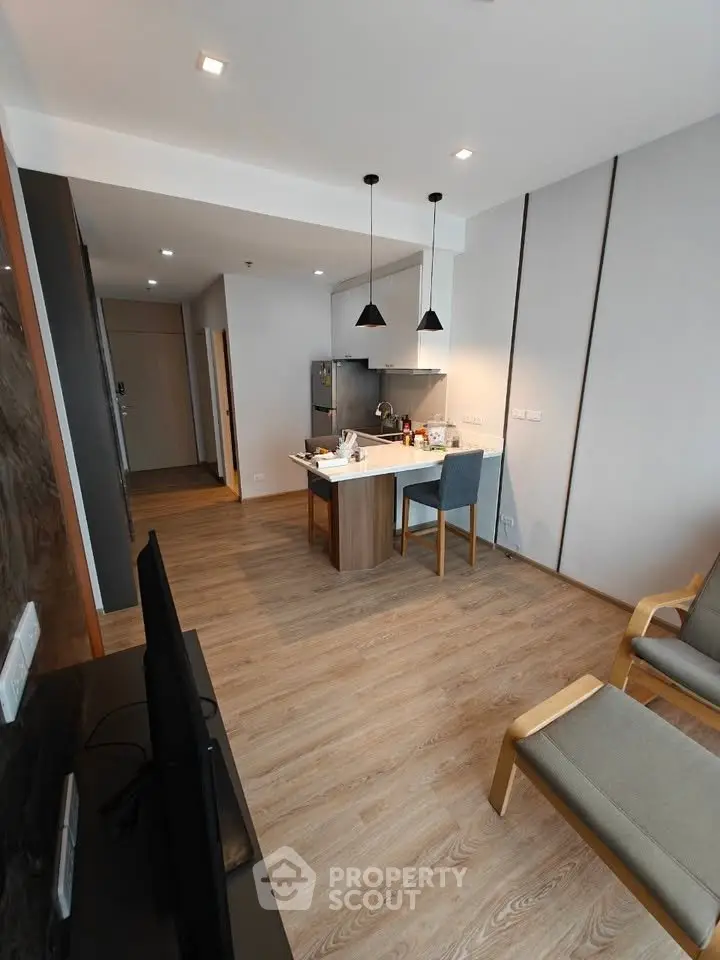 Modern open-plan living room with sleek kitchen and stylish furnishings.