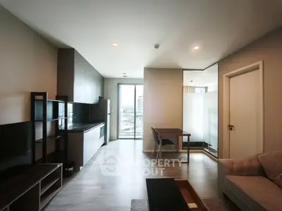 Modern open-plan living room with sleek kitchen and balcony view