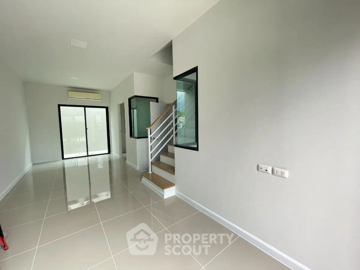 Spacious modern interior with sleek staircase and large windows, perfect for contemporary living.