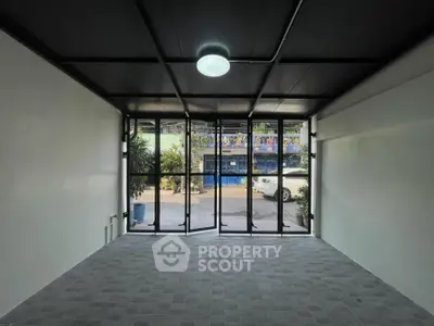 Spacious room with large glass doors and modern lighting, ideal for versatile use.
