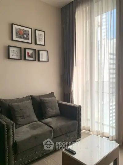 Cozy living room with stylish sofa and modern decor, featuring large windows for natural light.