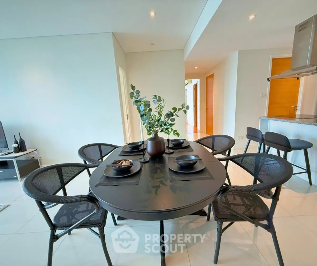 Modern dining area with sleek black table and chairs in open-plan layout