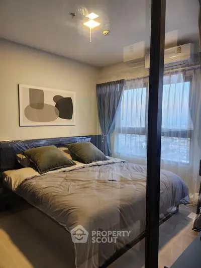 Modern bedroom with large window and stylish decor in a high-rise apartment.