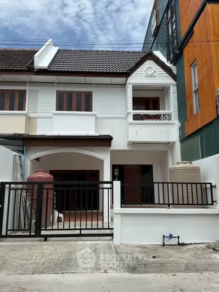 Charming townhouse with modern facade and gated entrance in a vibrant neighborhood.