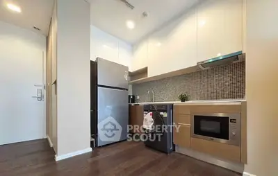Modern kitchen with sleek appliances and stylish cabinetry in a compact layout.