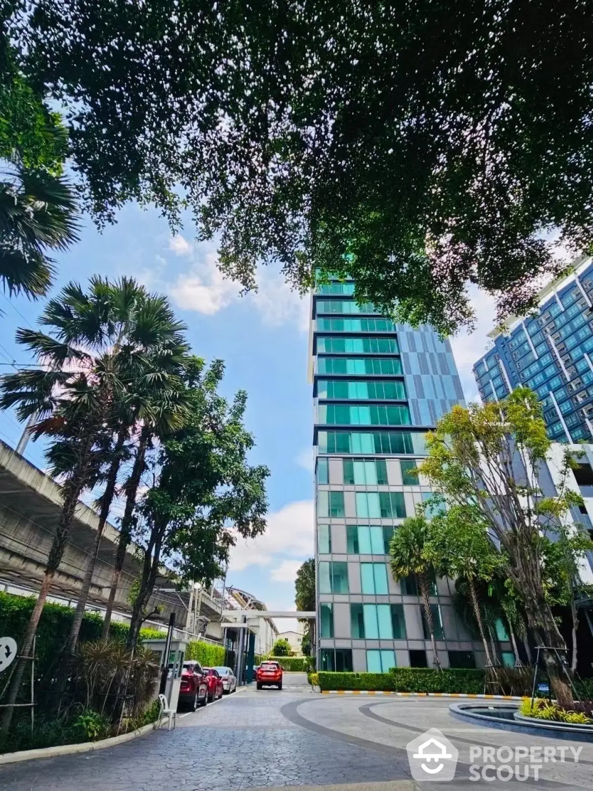 Modern high-rise building with lush greenery and clear blue sky