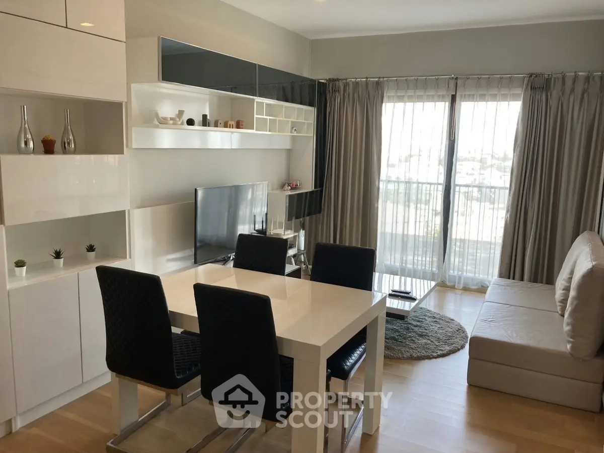 Modern living room with sleek furniture and large windows offering natural light and a cozy atmosphere.