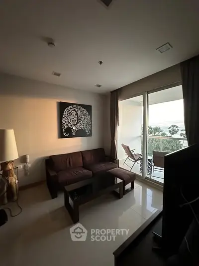 Modern living room with balcony and stylish decor, offering a serene view.