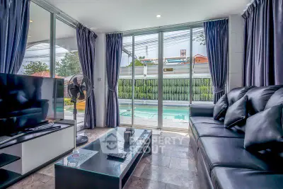 Luxurious living room with pool view, modern furnishings, and ample natural light.