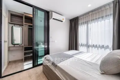 Modern bedroom with large window and built-in wardrobe in stylish apartment
