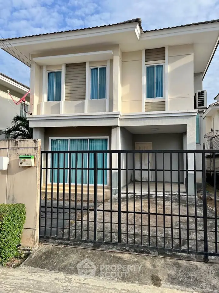 Charming two-story house with modern design and gated entrance in a serene neighborhood.