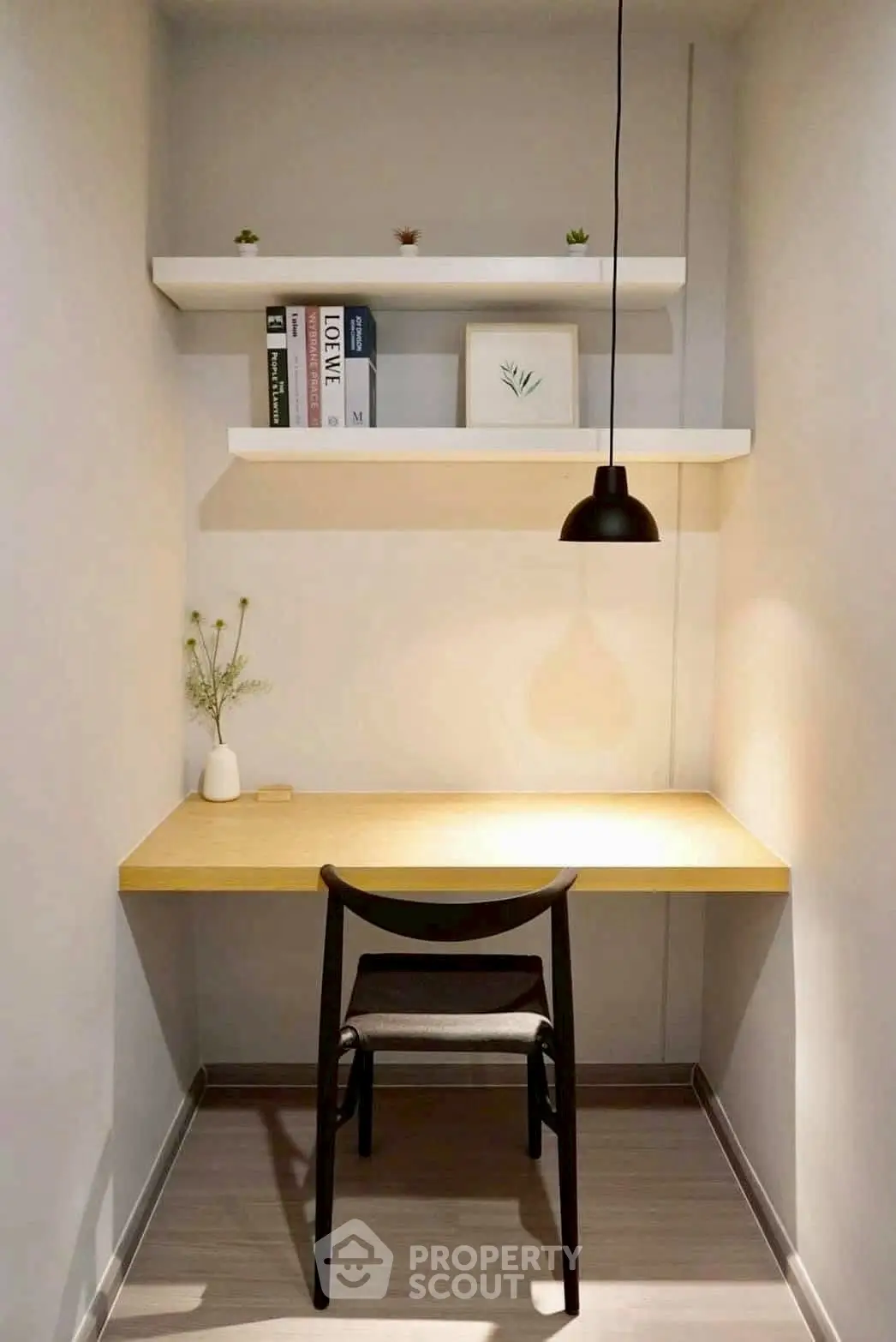 Cozy minimalist study nook with desk, chair, and shelves in modern apartment.