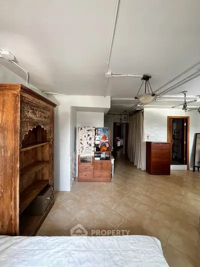 Spacious bedroom with rustic wooden furniture and tiled flooring, offering a cozy and inviting atmosphere.