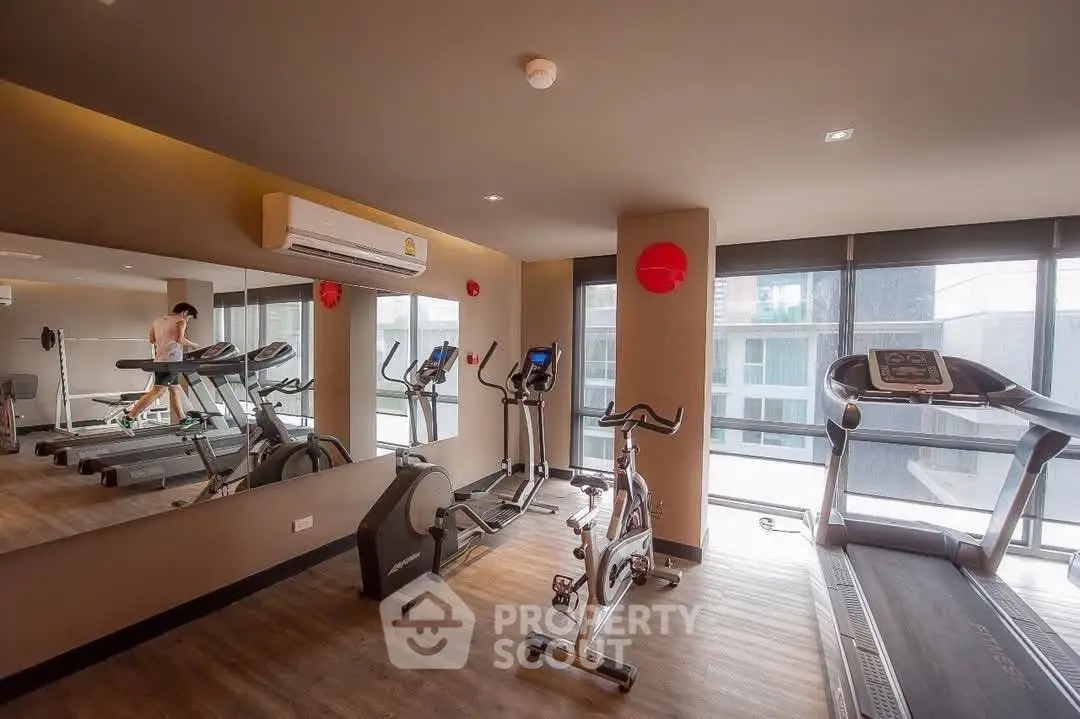 Modern gym with state-of-the-art equipment and large windows for natural light.