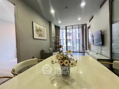 Modern living room with stylish decor and large windows offering natural light.