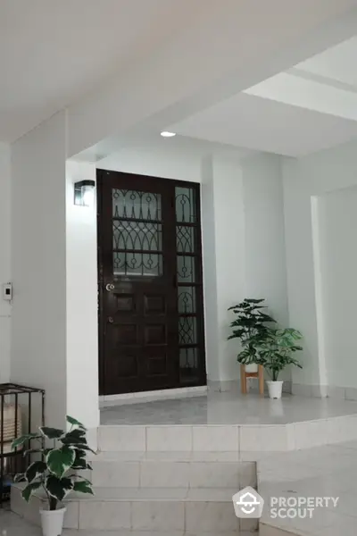 Elegant entrance with marble steps and decorative plants enhancing curb appeal