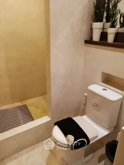 Modern bathroom with minimalist design and potted plants for a serene ambiance.