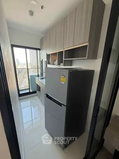 Modern kitchen with sleek cabinetry and stainless steel fridge, offering a bright and functional space.