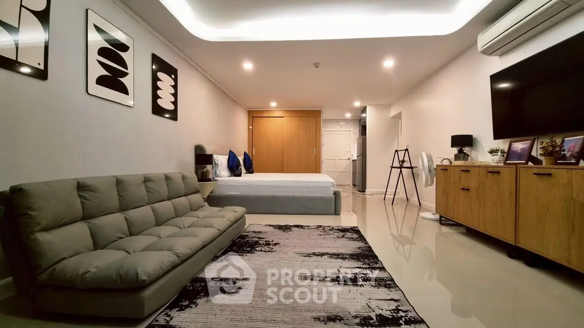 Modern studio apartment with sleek decor, featuring a cozy living area and stylish bedroom setup.