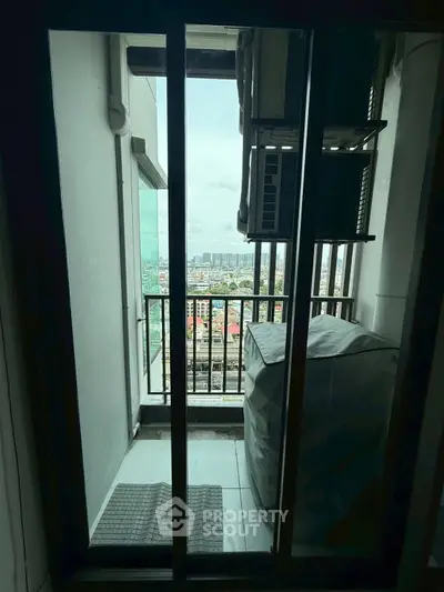 Compact balcony with city view, ideal for urban living, featuring air conditioning unit and protective cover.