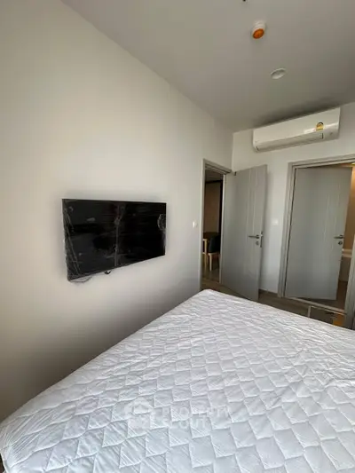 Modern bedroom with wall-mounted TV and air conditioning unit